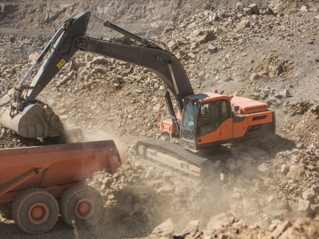 Quarry worker operating heavy machinery in quarry